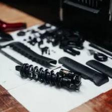 Rozłożony amortyzator i elementy serwisowe na stole warsztatowym